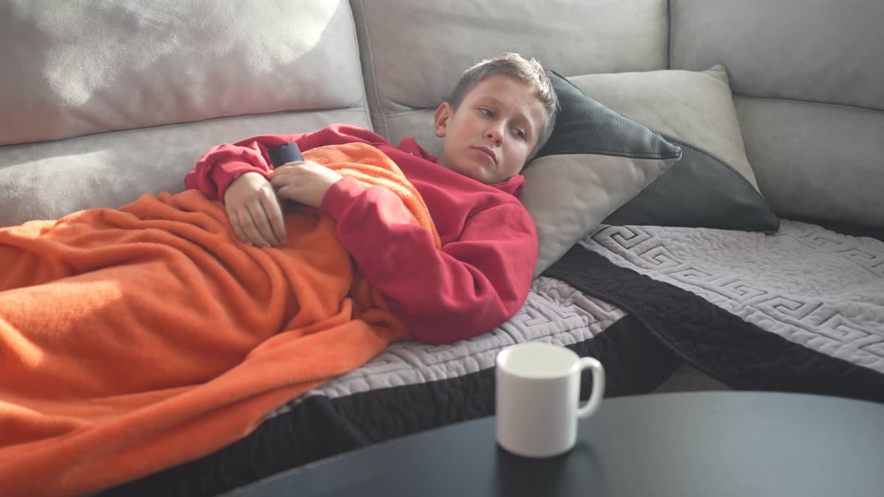 患有COVID-19的儿童躺在床上，起床喝药视频下载