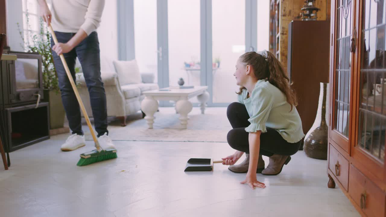 一个爸爸和女儿在家一起打扫客厅的4k视频视频素材