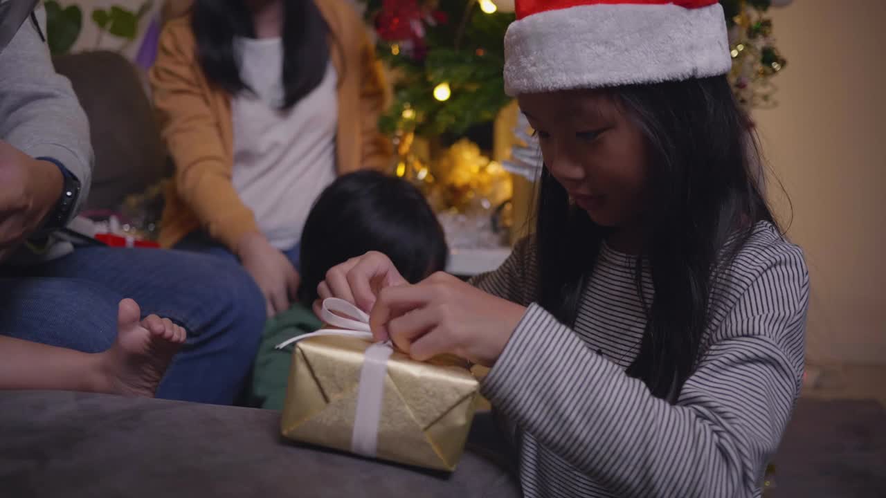 快乐的家庭和女儿享受圣诞礼物盒打开视频素材