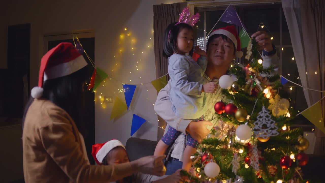 家人和兄弟姐妹在享受圣诞节，孩子们在装饰圣诞树视频素材
