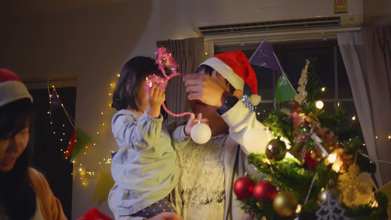 家人和兄弟姐妹在享受圣诞节，孩子们在装饰圣诞树视频素材