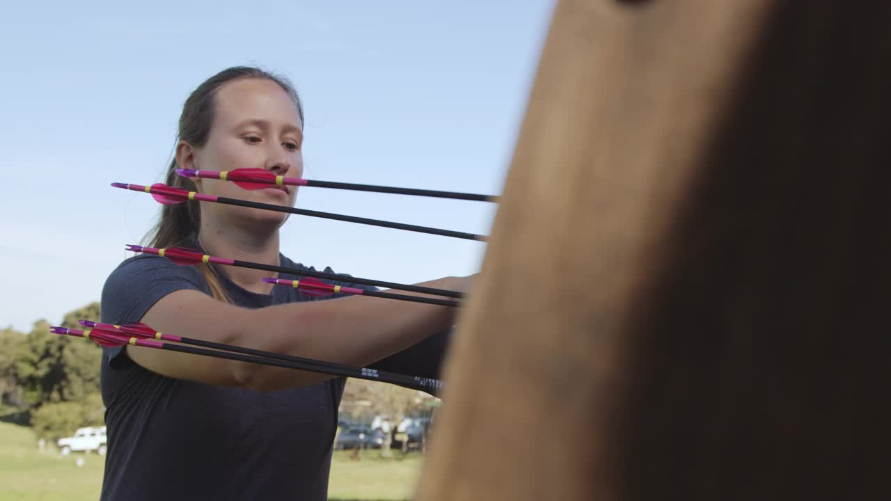 一个有吸引力的年轻女弓箭手练习她的手艺在射箭范围的4k视频镜头视频素材
