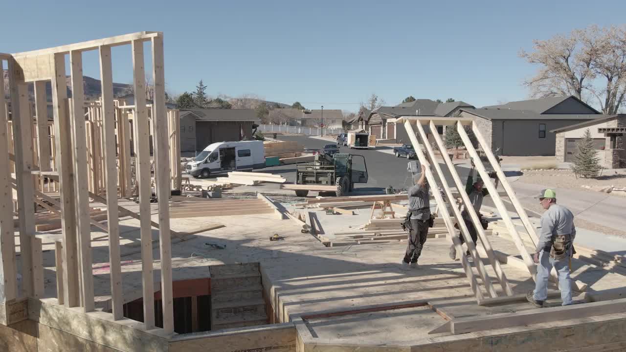 3名白人木匠在房屋建筑工地上架起一堵墙视频素材