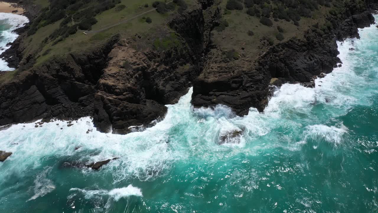 在澳大利亚新南威尔士州帽子岬岬，海浪撞击悬崖底部的鸟瞰图。视频素材