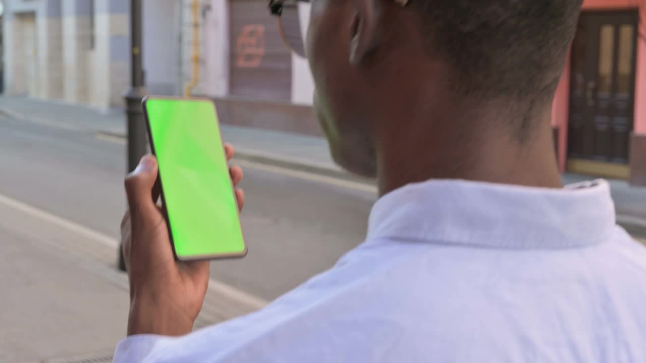 非洲人看着绿色屏幕的智能手机视频素材
