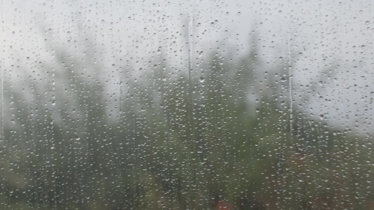 雨滴落在玻璃上。在阴天收集水分。视频素材
