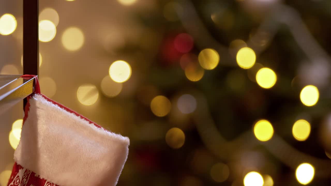 一个圣诞故事，圣诞老人的手用他的手指啪的一声，礼物出现在圣诞袜子里。视频下载