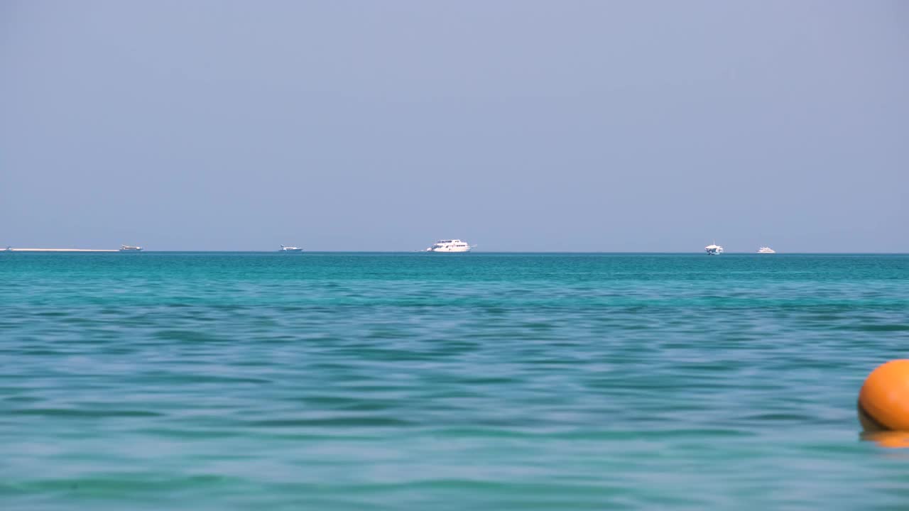 海景与波浪表面的蓝色海水与遥远的船只漂浮在平静的波浪视频素材