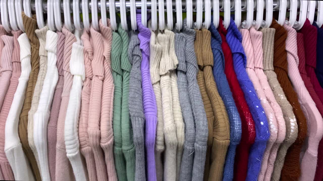 不同颜色的女套头衫，衣服挂在商店的衣架上视频下载