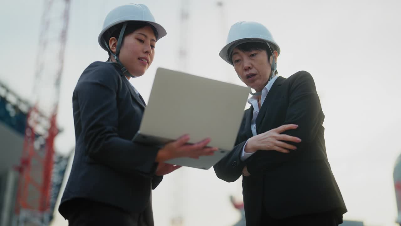 两个女工程师在工地上一起工作视频素材