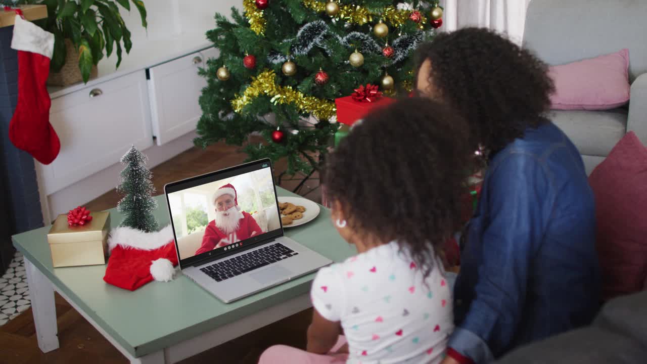 快乐的非洲裔美国母亲和女儿在圣诞期间与圣诞老人视频电话视频下载