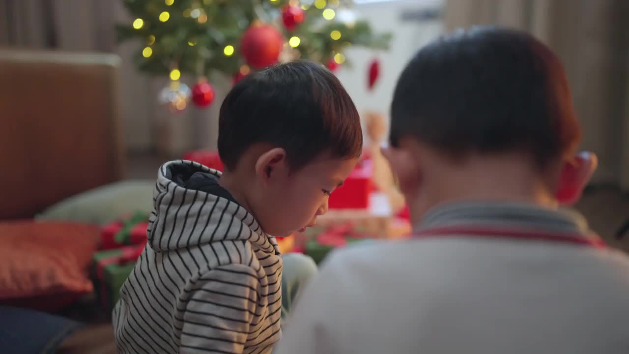 亚洲小朋友一起玩耍，用欢快而有趣的笑容装饰圣诞树，亚洲小朋友在家里一起玩耍，一起生活在家里视频素材