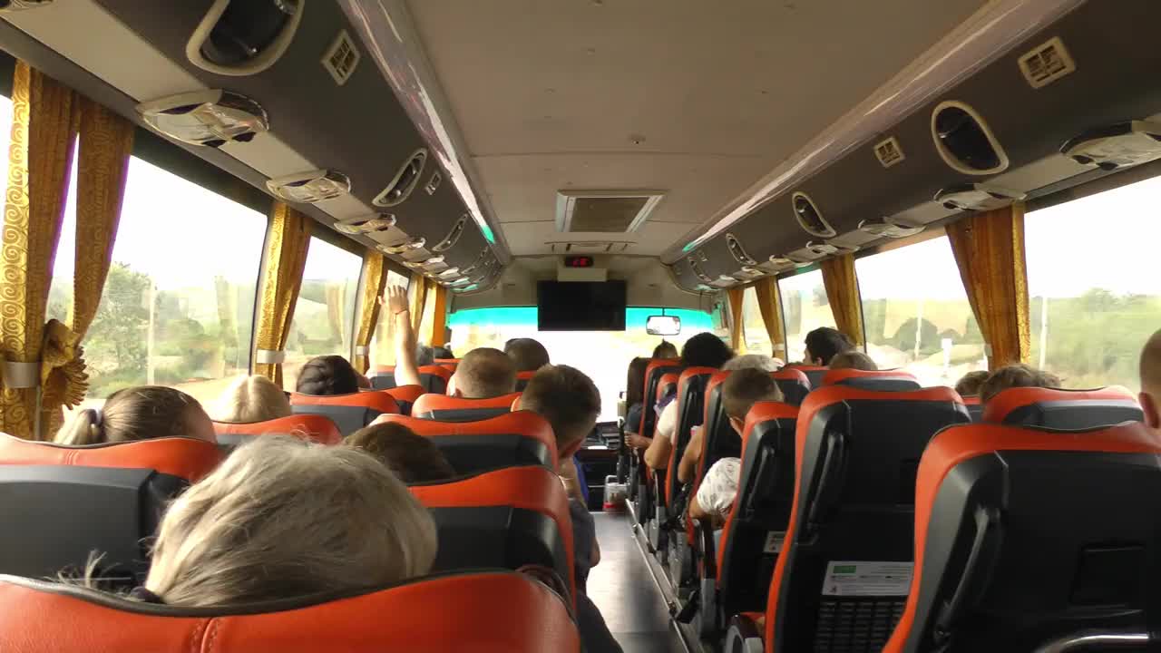 旅游巴士载着游客在路上旅行。从后面看里面。旅行和旅游视频下载