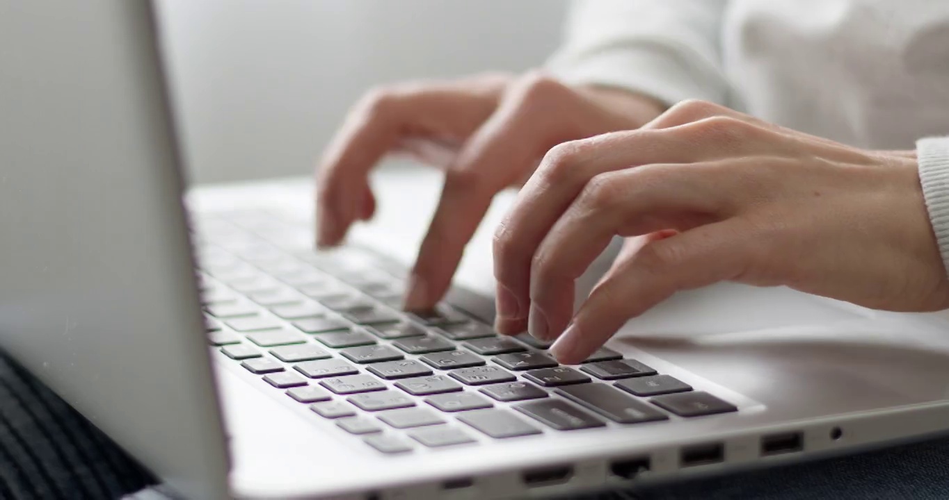 女性的手指正在笔记本电脑的键盘上打字。商业女性使用电脑工作。特写镜头。视频素材