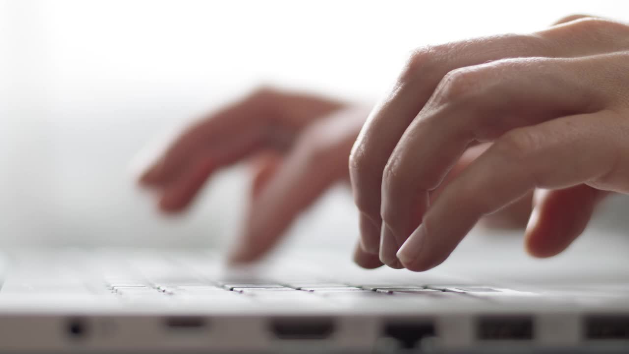 女性的手指正在笔记本电脑的键盘上打字。商业女性使用电脑工作。特写镜头。视频素材