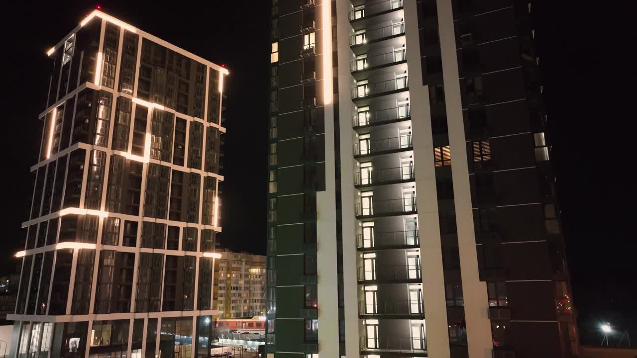 现代高层建筑在夜间照明的鸟瞰图。夜城中的两座高大的房子。高层建筑中的商务中心视频下载