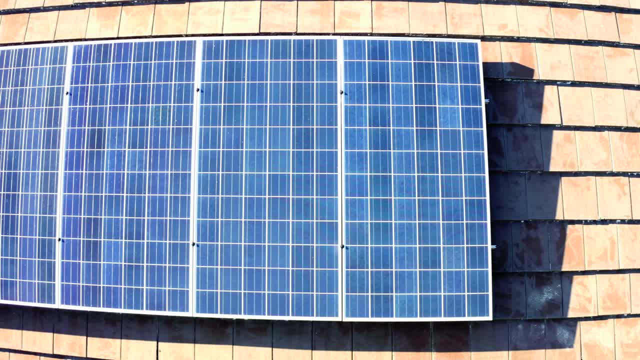 住宅建筑屋顶的太阳能电池板产生绿色生态电力。股票视频视频素材