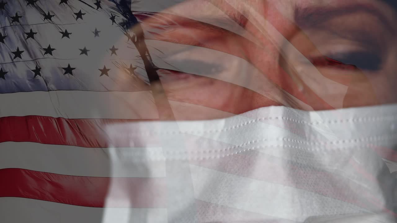 悲伤的悲伤的医生或护士戴着医用口罩与鬼影慢动作挥舞美国国旗的特写。视频下载