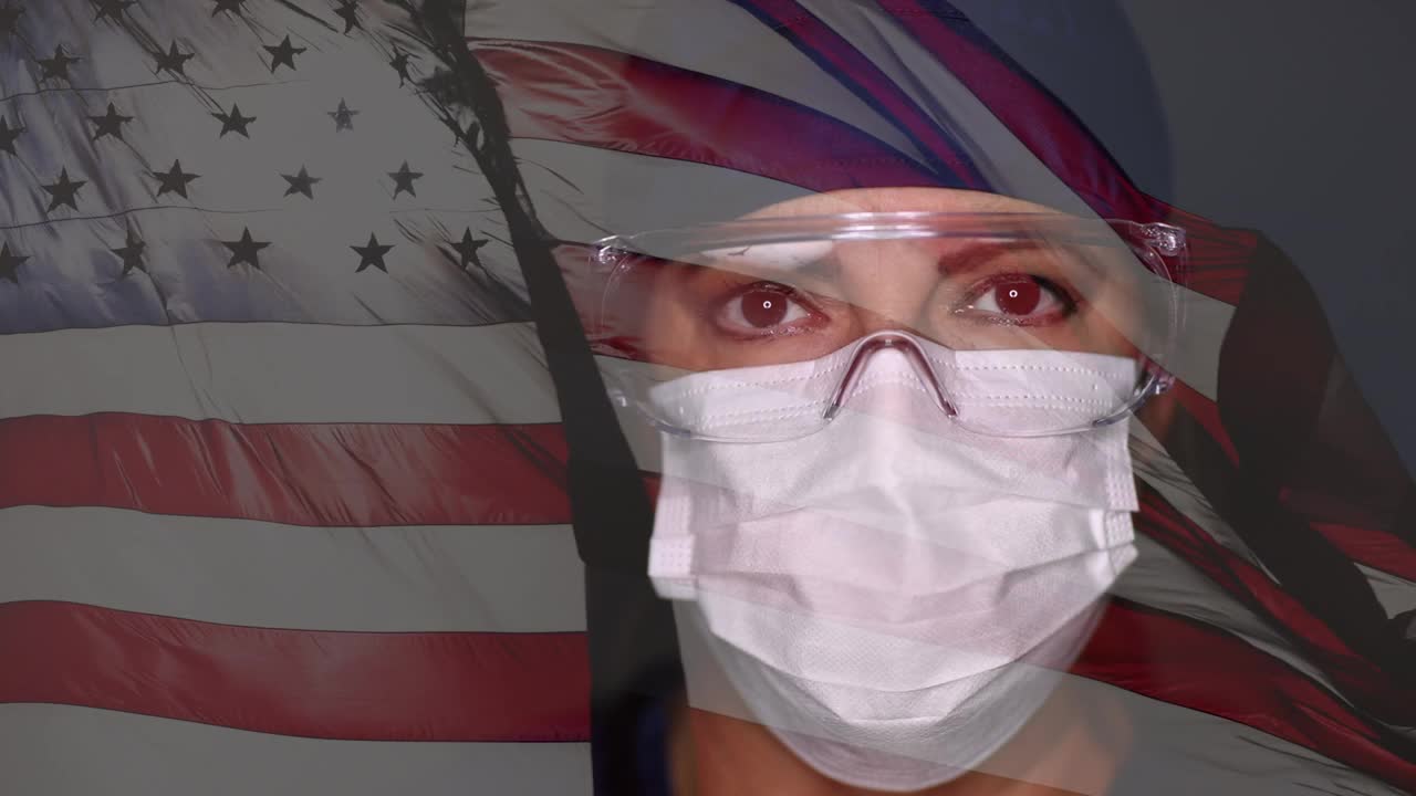 女医生或护士摘掉医用口罩和防护眼镜，并以鬼影慢动作挥舞美国国旗。视频下载
