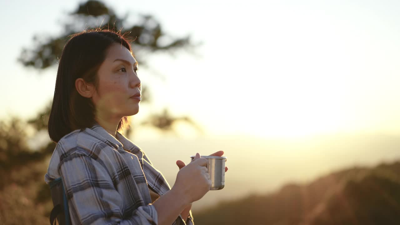 女人在户外放松与咖啡杯在山上的日落时间视频下载