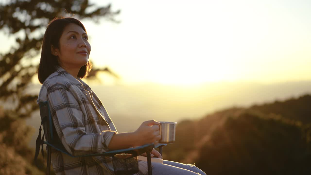 女人在户外放松与咖啡杯在山上的日落时间视频素材