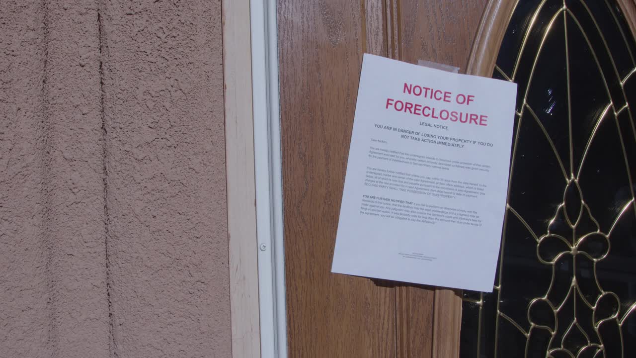 复制空间拍摄的一张纸止赎通知贴在一个住宅郊区社区的玻璃前门视频下载