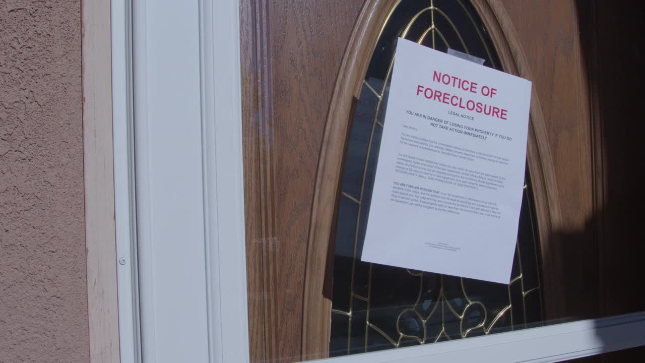 手持式拍摄的纸止赎通知粘在玻璃前门的住宅郊区社区视频下载