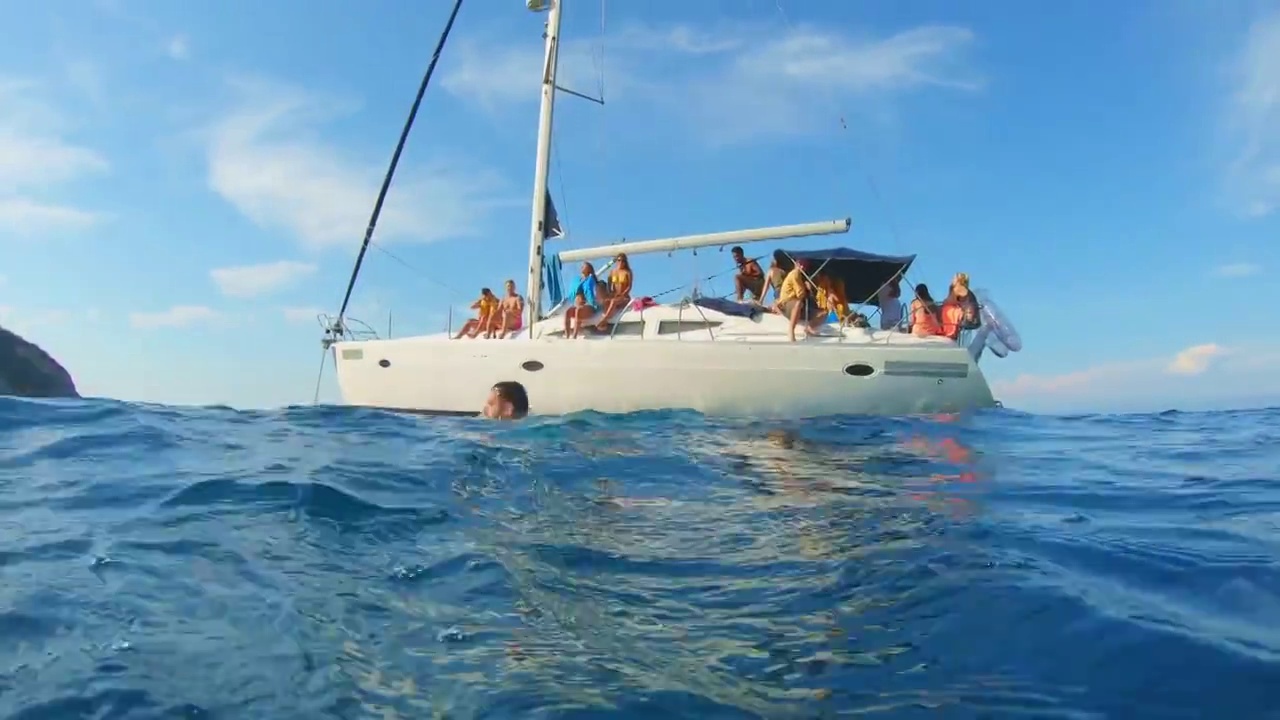 一名男子从船上跳入海中，与水中的朋友击掌庆祝视频下载