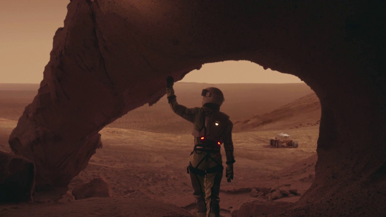 探索火星表面的女宇航员。铁锈色的岩石。背景中的火星探测器视频下载