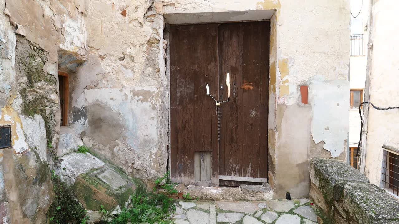 一座废弃的老房子的门用铁链和挂锁锁着。视频下载