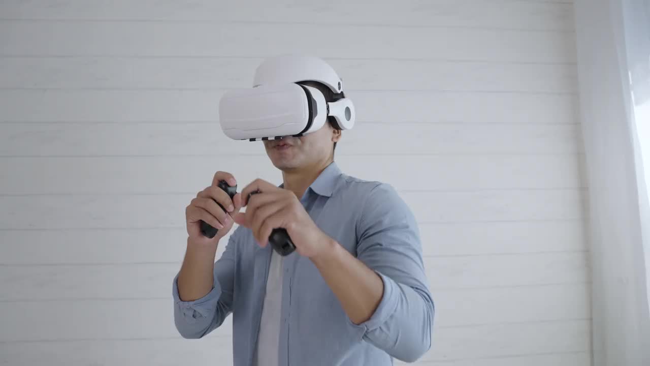 年轻的西班牙男子戴着虚拟现实耳机在家玩模拟拳击游戏视频下载