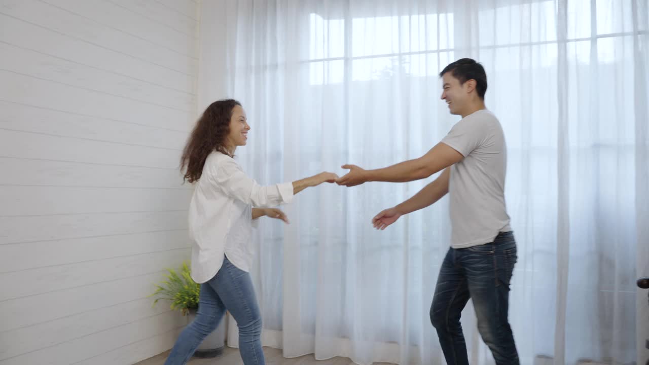 快乐的西班牙年轻夫妇在卧室里跳舞视频下载
