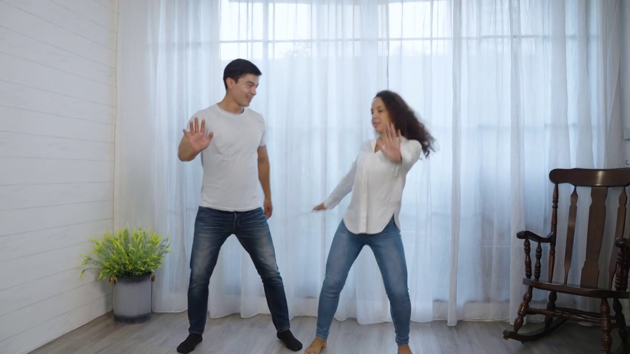 快乐的西班牙年轻夫妇在卧室里跳舞视频下载