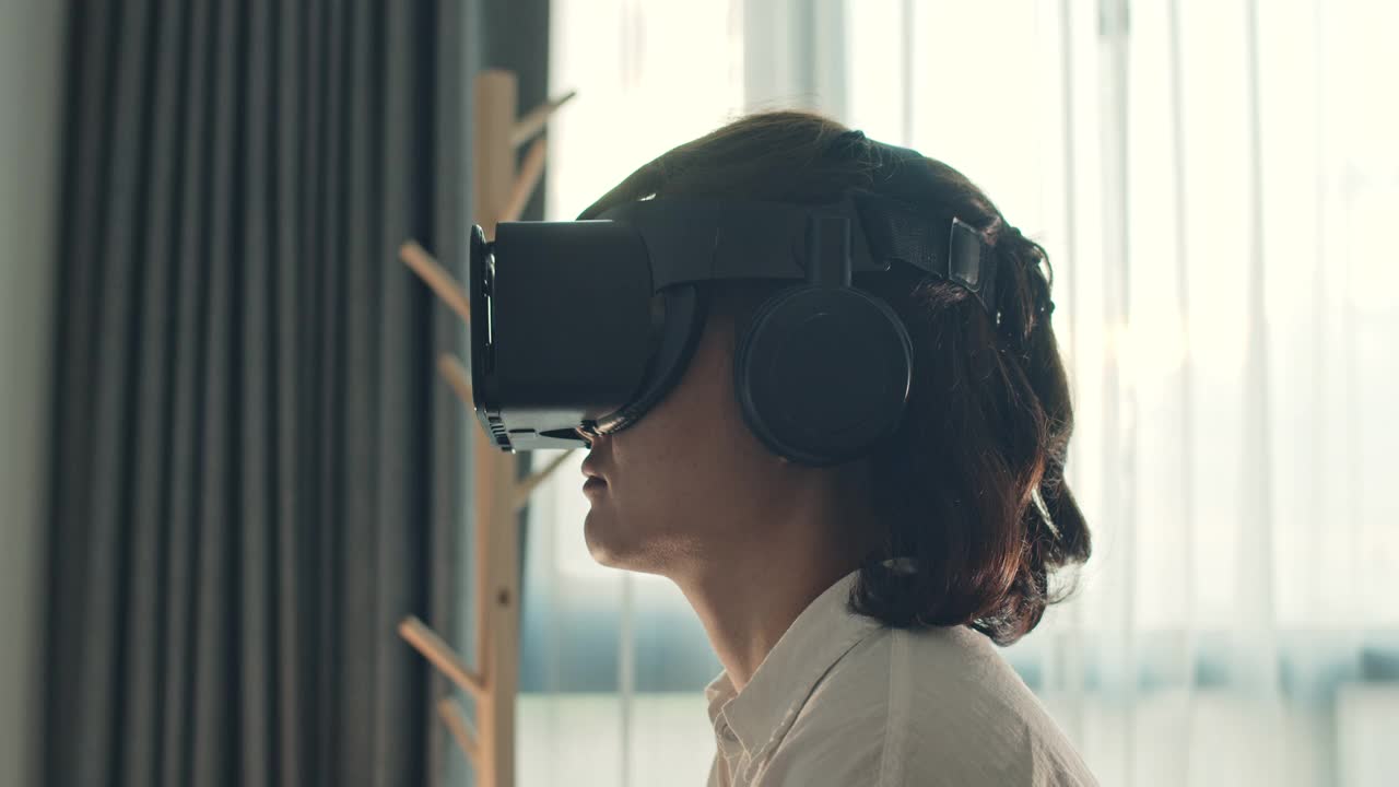 亚洲女性戴着虚拟现实耳机躺在床上，慢动作视频素材
