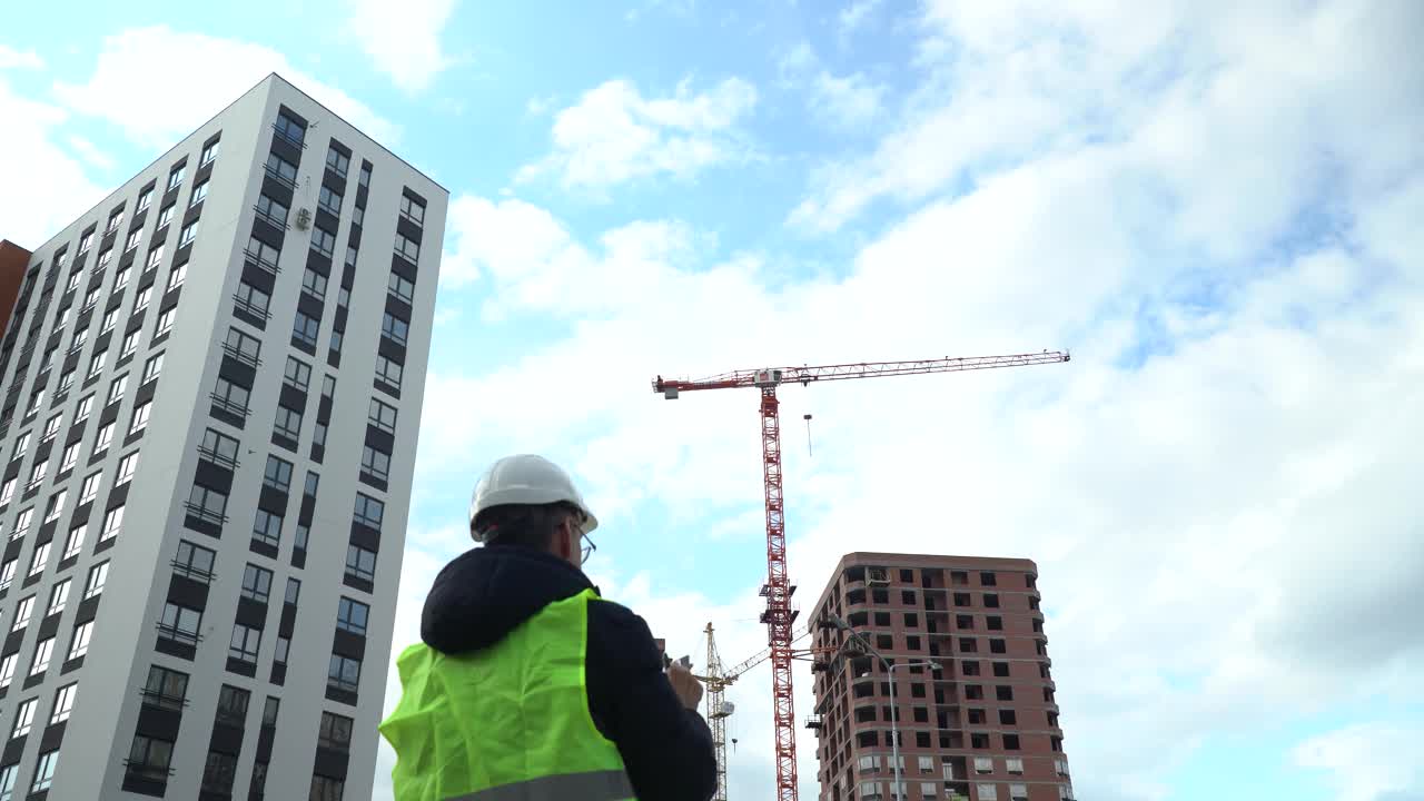 戴着头盔的工人注视着建筑工地视频素材