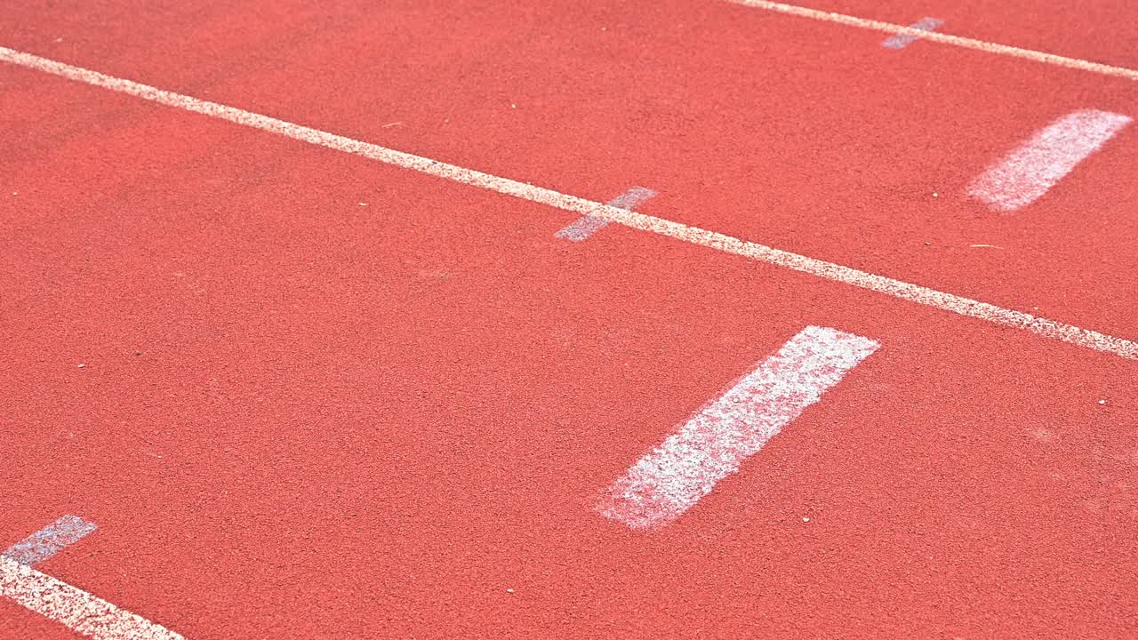 镜头视频的运动员女跑步者在开始位置准备冲刺在跑道在体育场。视频素材