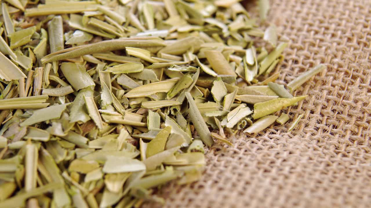 干橄榄叶放在粗糙的粗麻布上。健康草本茶粉成分。宏视频素材