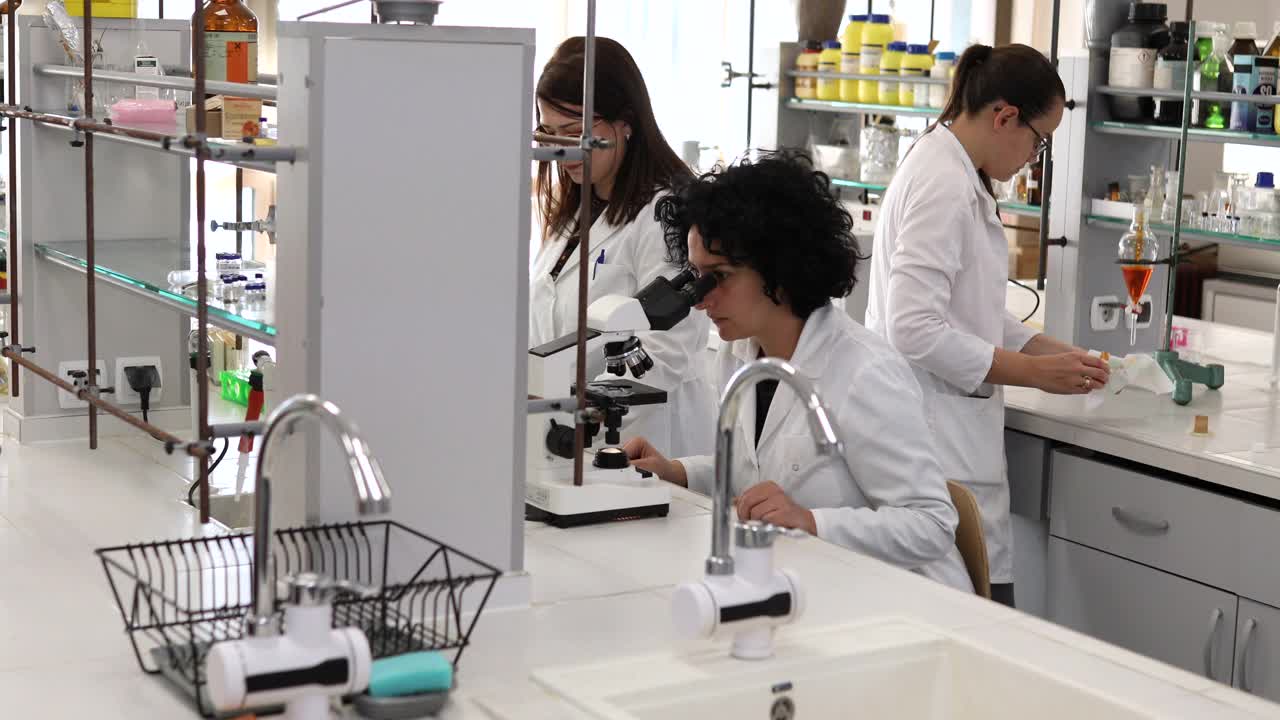 一群有经验的科学家正在一个现代化的实验室里做实验。视频下载