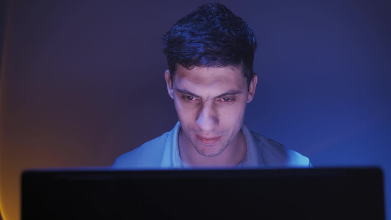 男子微笑着用笔记本电脑上网看娱乐视频。视频素材