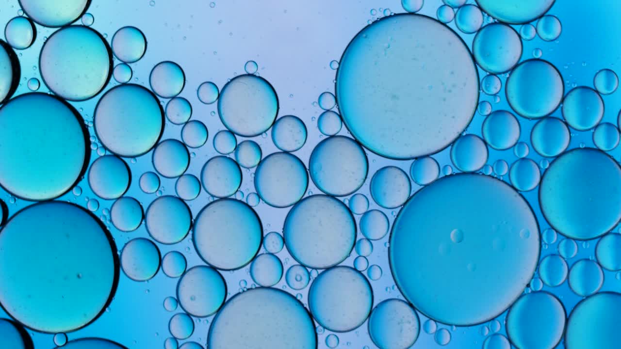在蓝色背景上移动的液体气泡的完整框架。视频素材