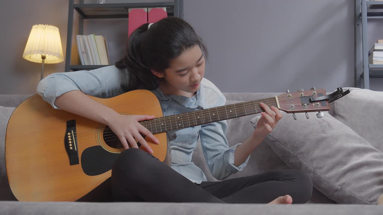快乐少女在家里的客厅弹吉他，创意爱好视频下载