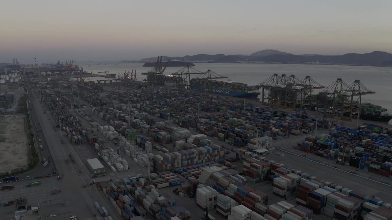 日落之后的海港码头上，卡车仍在密集的集装箱间忙碌穿梭视频素材