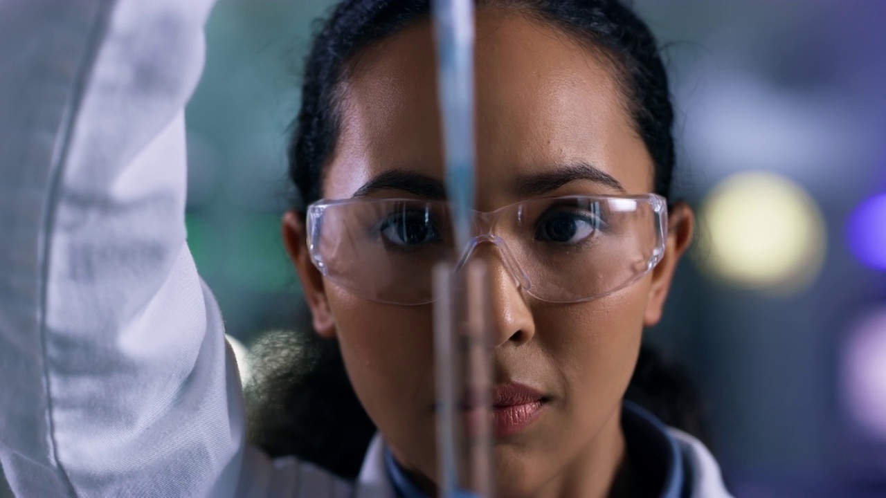 一个年轻女子在实验室里使用滴管和试管的4k视频片段视频素材