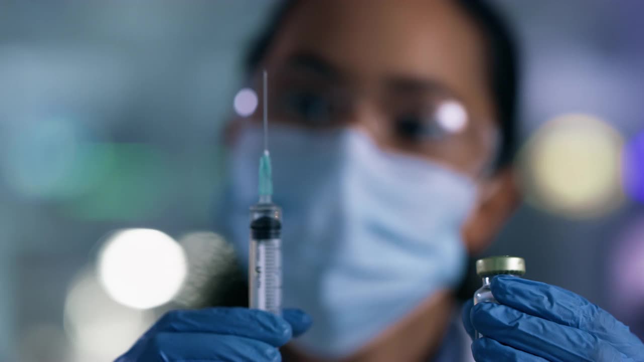 一个科学家在实验室里使用注射器和小瓶的4k视频片段视频素材