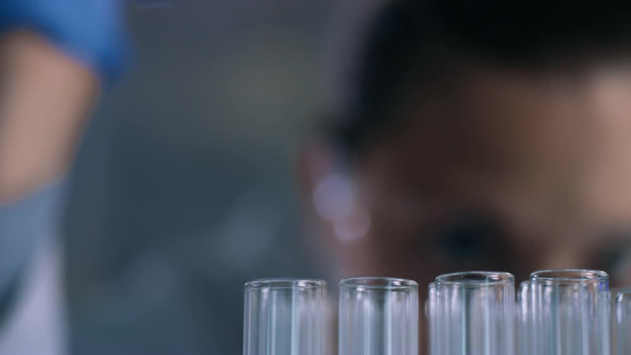 一个无法辨认的科学家在实验室里使用滴管和试管的4k视频片段视频素材