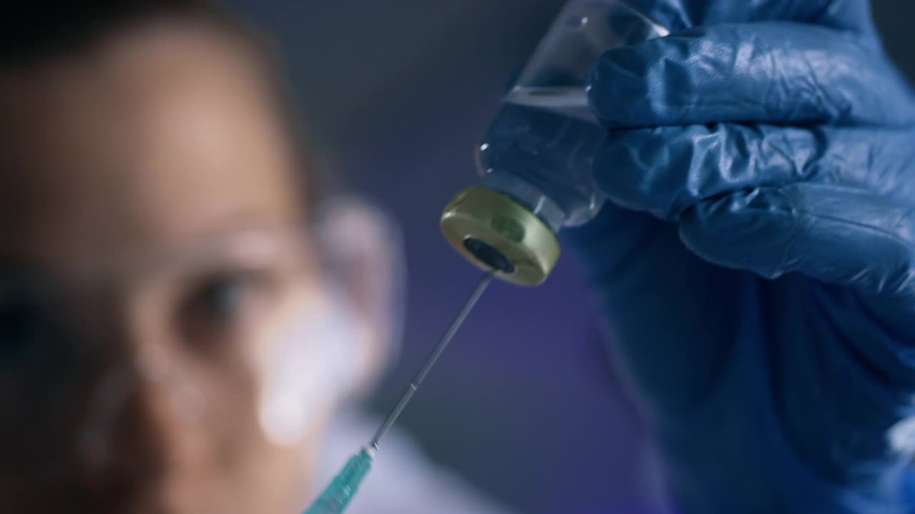 一个科学家在实验室里使用注射器和小瓶的4k视频片段视频素材