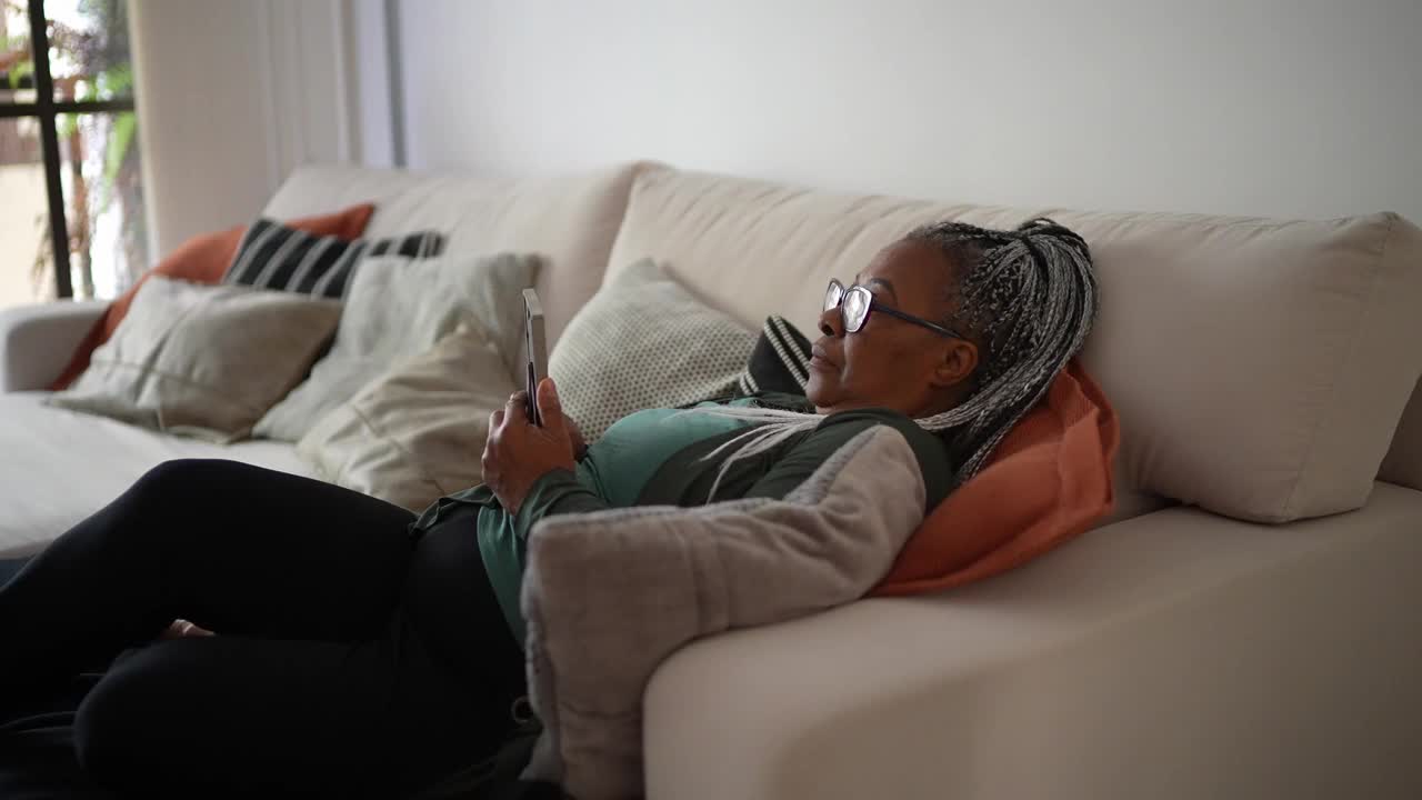 一位年长的妇女拿着一个相框，想念家里的某个人视频素材