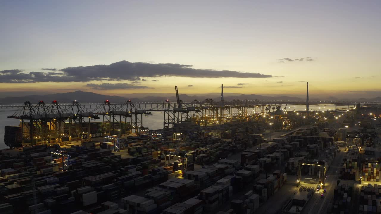 日落之后的海港码头上，卡车仍在密集的集装箱间忙碌穿梭视频素材
