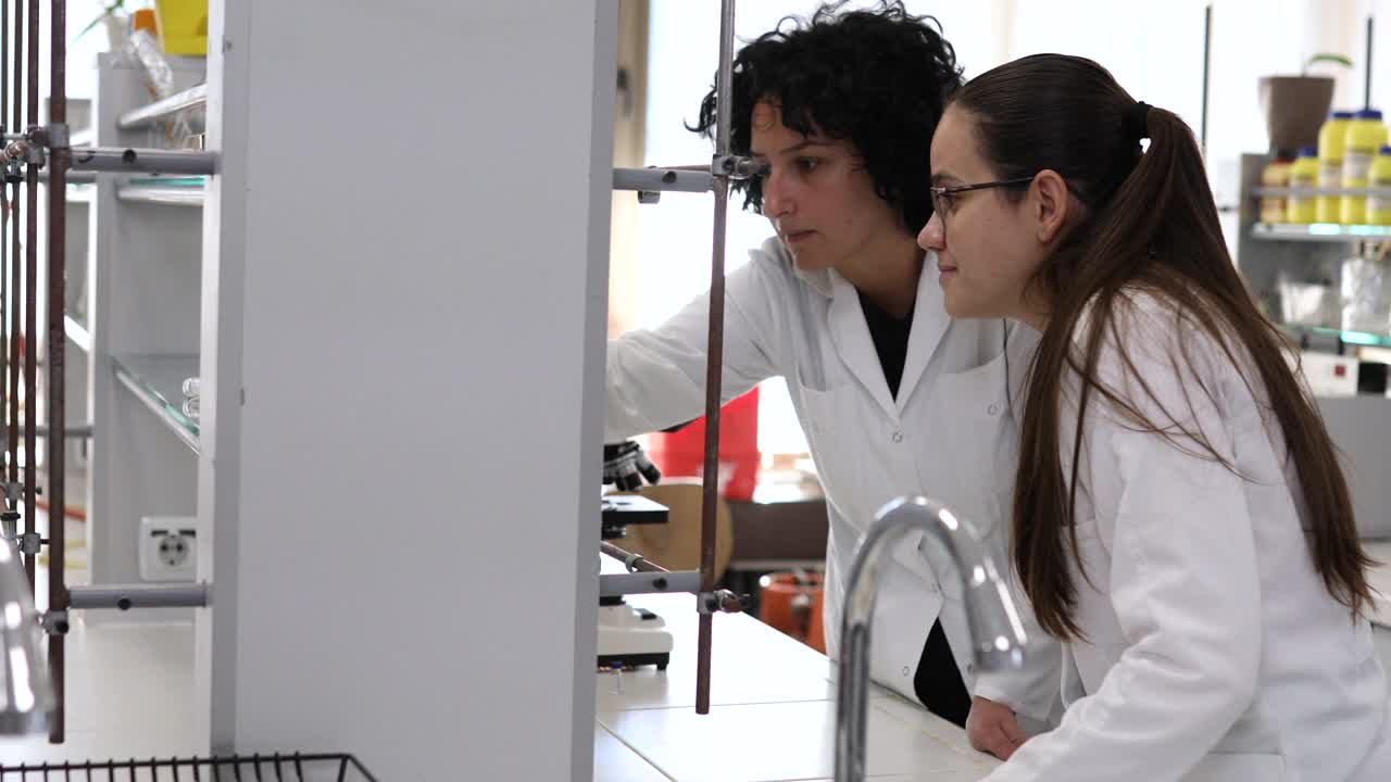 女性生物学家在现代实验室的团队合作。视频下载