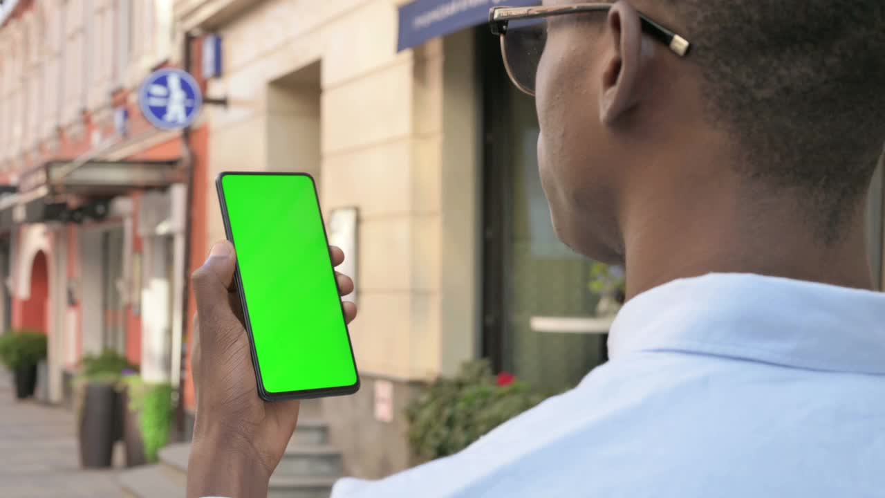 非洲人看着绿色屏幕的智能手机视频素材